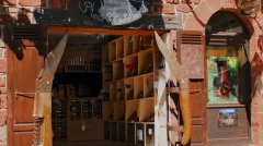 Giant wooden pocket knives used as window shutters on a traditional red sandstone knife shop in Collonges-la-Rouge, France.