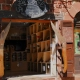 Giant wooden pocket knives used as window shutters on a traditional red sandstone knife shop in Collonges-la-Rouge, France.